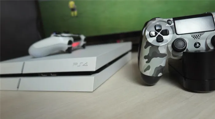 ps4 fat с джойстиком на ней и рядом с ней на подставке